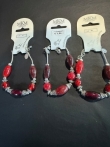 3 armbanden met rode kralen en zilverkleurige accenten