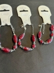 3 armbanden met rode kralen en zilverkleurige accenten